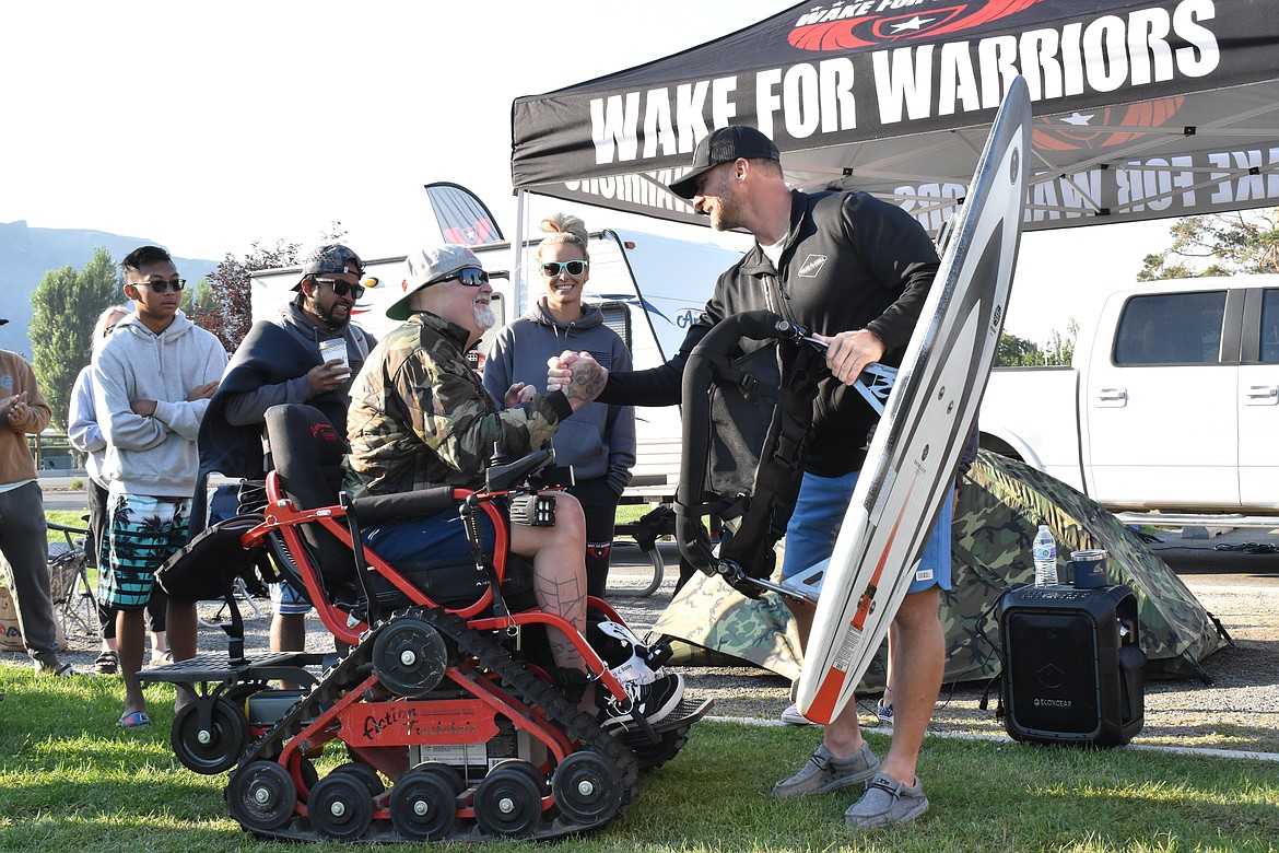 Matthew Hannon shakes hands with Luke Fournier of Wake N Grill, who presented him with a new sit-down wakeboard Saturday morning.