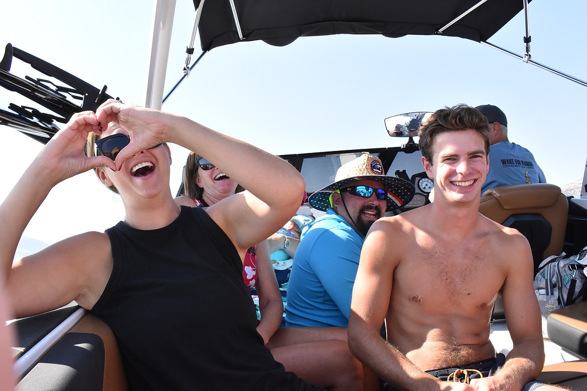 Those in the boats cheered on the participants in the water as they surfed.