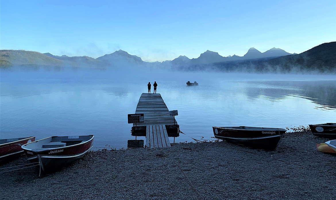 A couple watches the morning mist rise over Lake McDonald at Glacier National Park on Saturday.