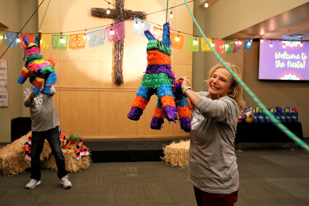 JoAnn Zajicek, director of the Union Gospel Mission Center for Women and Children in Coeur d'Alene, and Phil Altmeyer, UGM executive director, try to break open pinatas during UGM's 10-year celebration Thursday night.