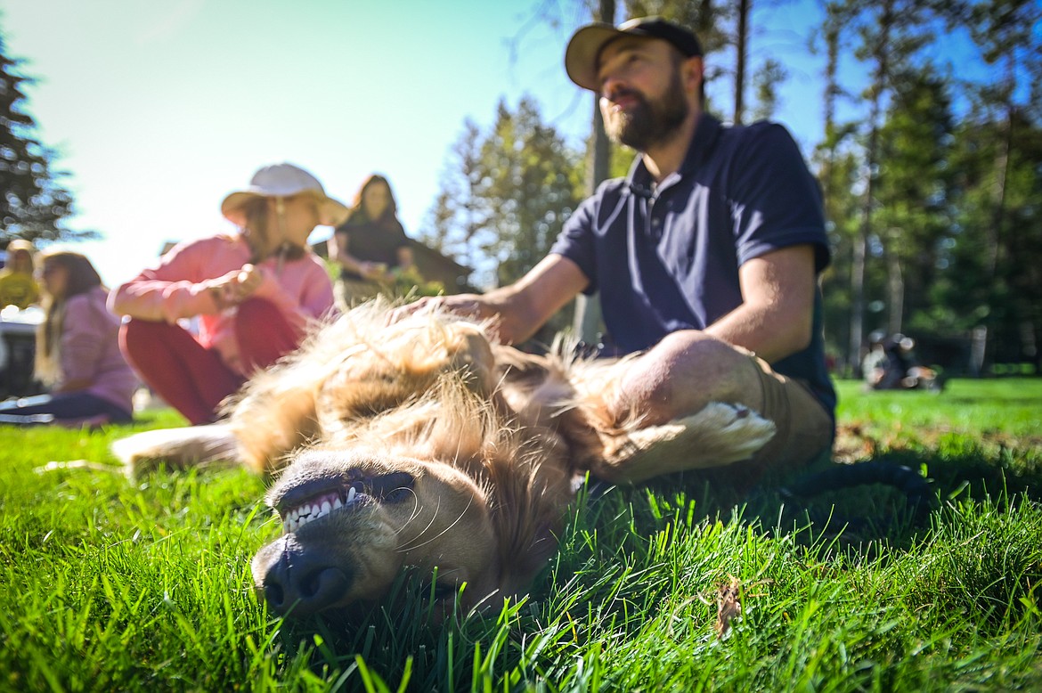 Tyler Kiser watches a demonstration while his golden retriever Ranger snoozes at GoldenStock Montana at Haymoon Resort in Whitefish on Saturday, Sept. 17. GoldenStock Montana is a gathering of golden retrievers and their owners to support Montana Precious Gold golden retriever rescue. (Casey Kreider/Daily Inter Lake)