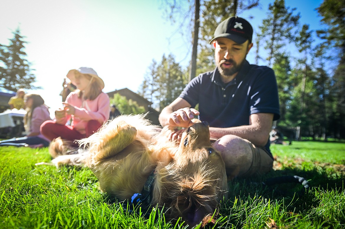 Tyler Kiser watches a demonstration with his golden retriever Ranger at GoldenStock Montana at Haymoon Resort in Whitefish on Saturday, Sept. 17. GoldenStock Montana is a gathering of golden retrievers and their owners to support Montana Precious Gold golden retriever rescue. (Casey Kreider/Daily Inter Lake)