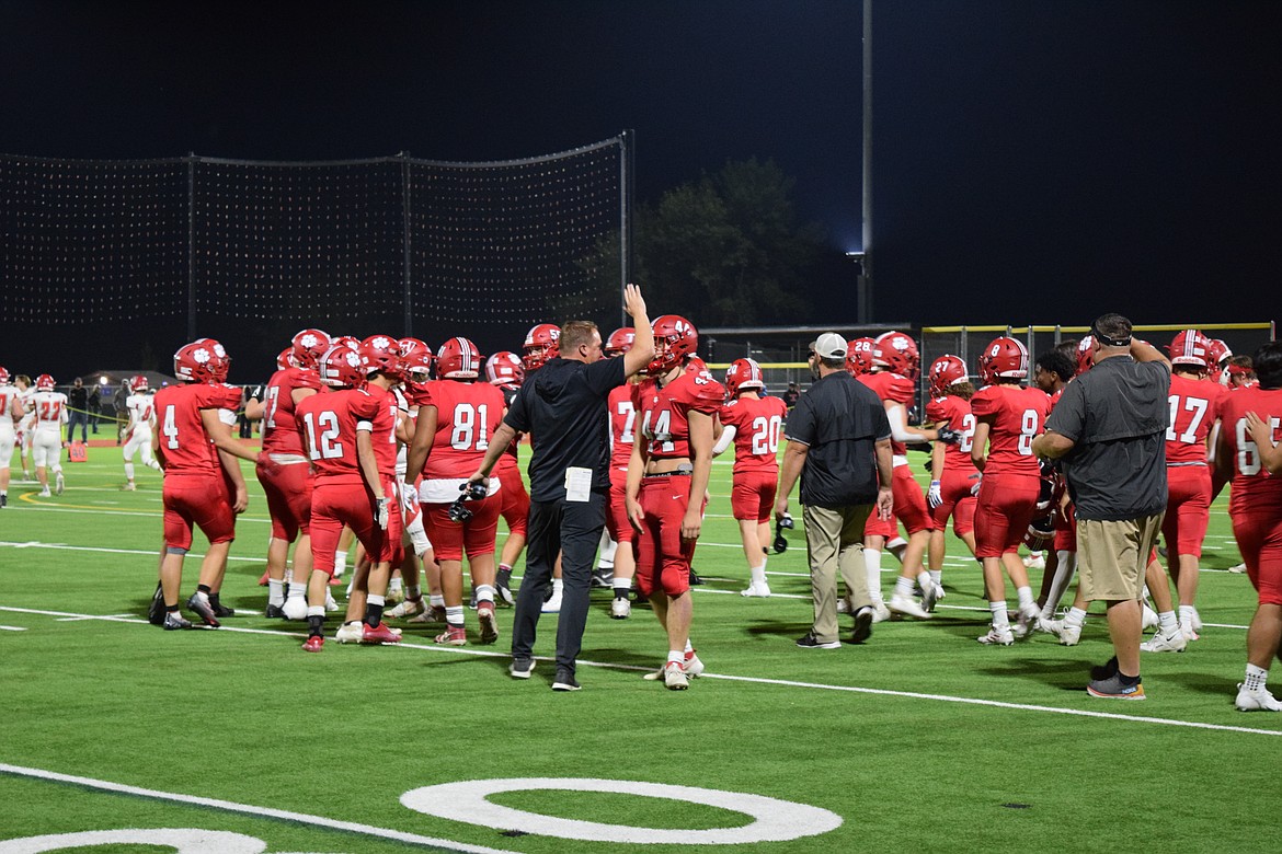 The Bulldogs gather on the field with their coaches after their win against the Homedale Trojans Friday evening.