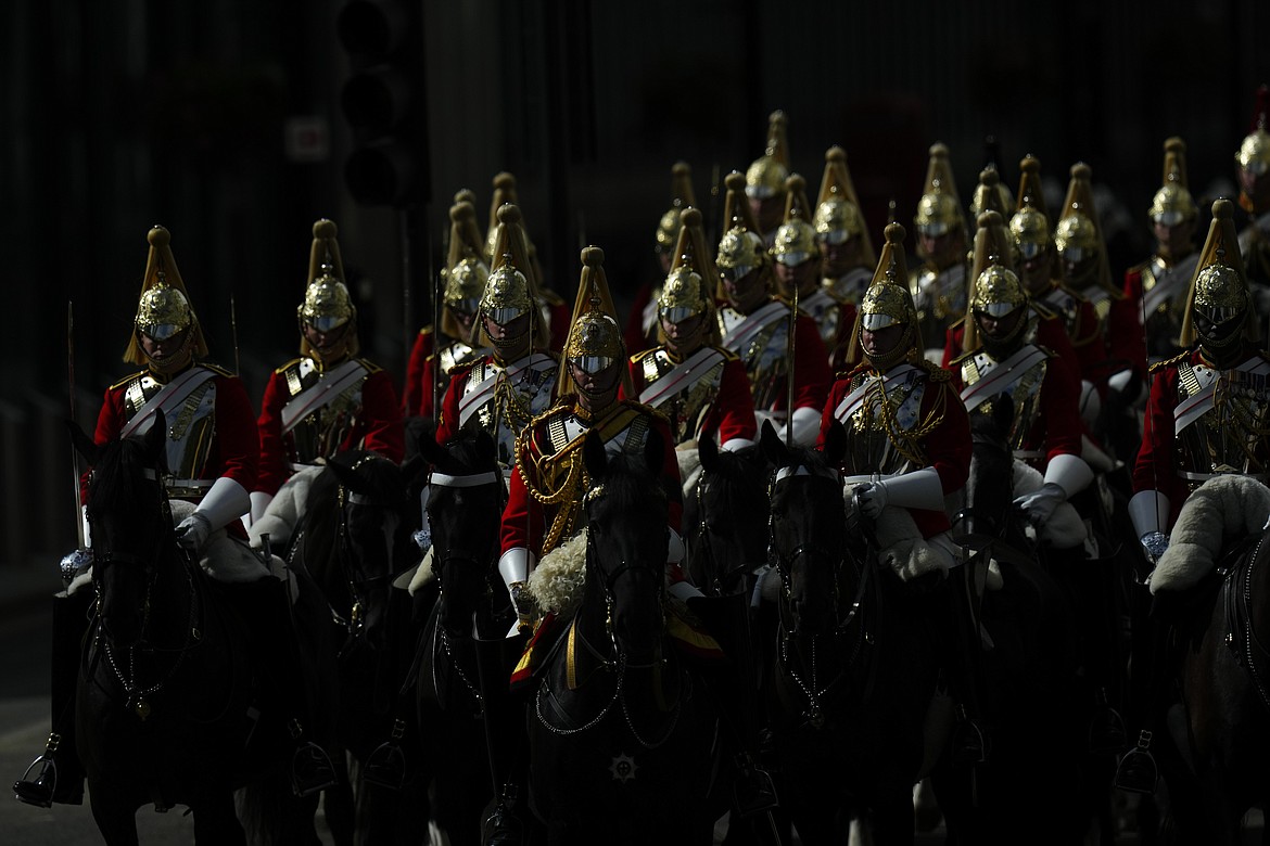 Royal mounted guards escort the coffin of Queen Elizabeth II to Westminster Abbey for her funeral in central London, Monday, Sept. 19, 2022. The Queen, who died aged 96 on Sept. 8, will be buried at Windsor alongside her late husband, Prince Philip, who died last year. (AP Photo/Petr David Josek, Pool)