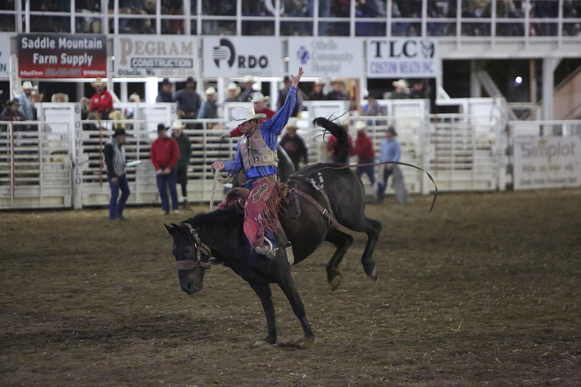 A saddle bronc rider maintains balance on a horse during the Othello PRCA Rodeo on Saturday night.