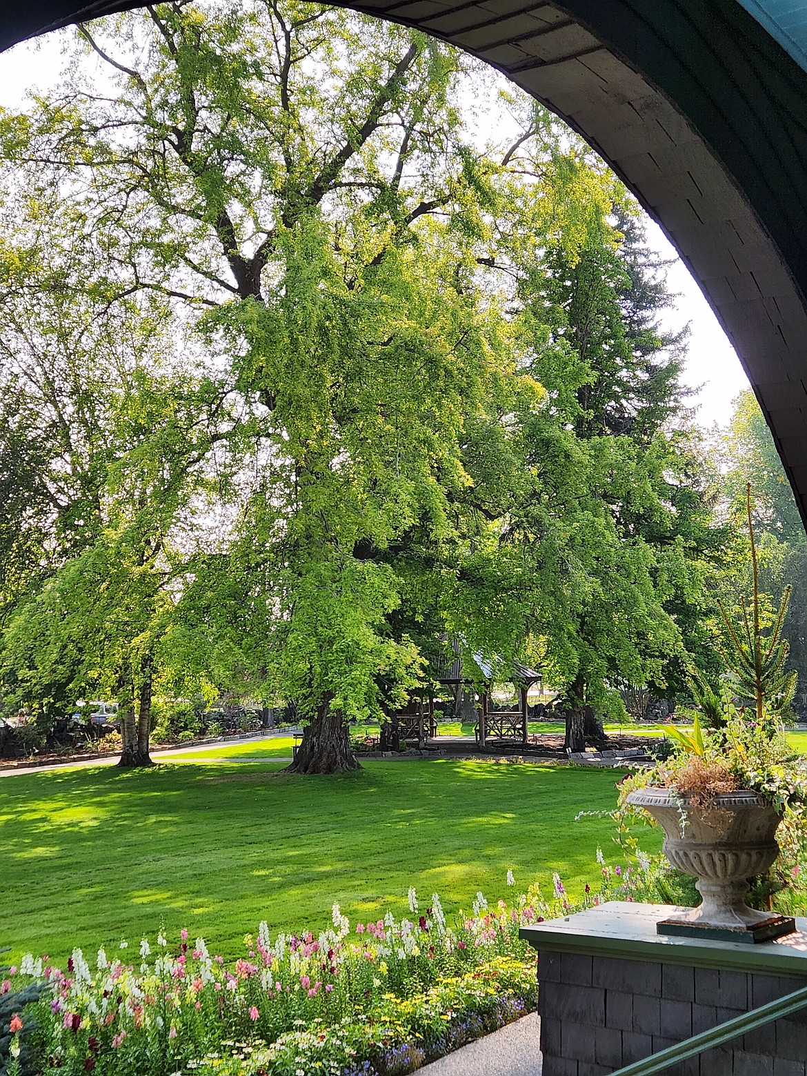 Conrad Mansion Museum's gardens looking from beneath the stone arch on the front porch - (Carol Marino/Daily Inter Lake)