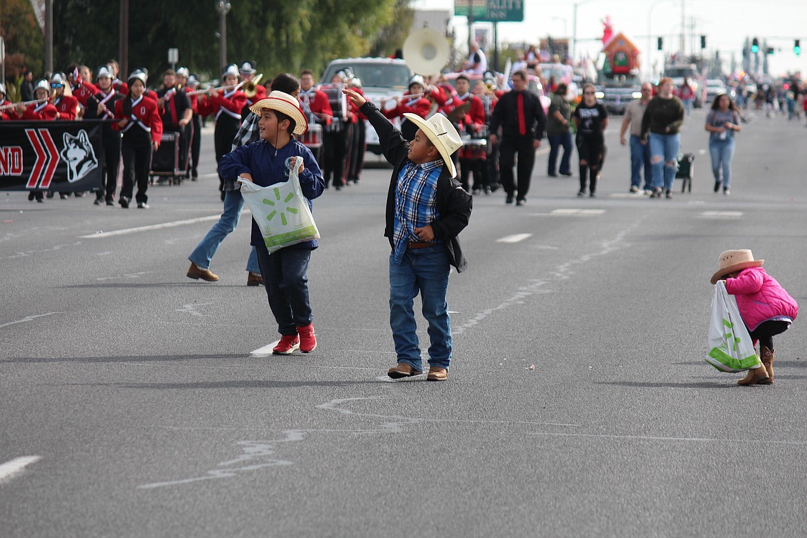 Children wave to parade participants during the Othello Fair Saturday.