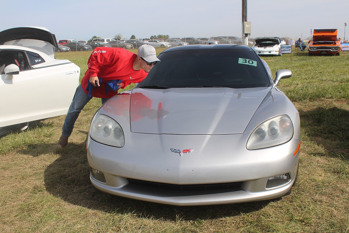 Josue Medina checks to see that that’s not a spot on the hood of his Corvette at Saturday’s Othello Fair car show.
