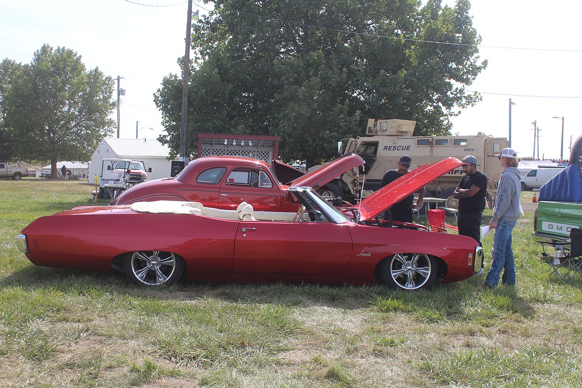 Connor Williamson’s 1969 Chevrolet Impala drew plenty of admirers at the Othello Fair car show. Williamson, right, talks to a couple of spectators.