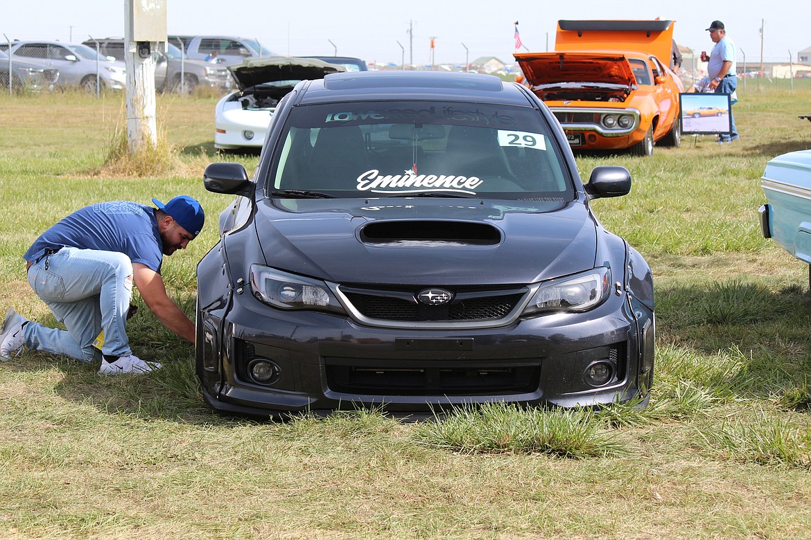 Johnny Suarez works on his car during the Othello Fair car show.
