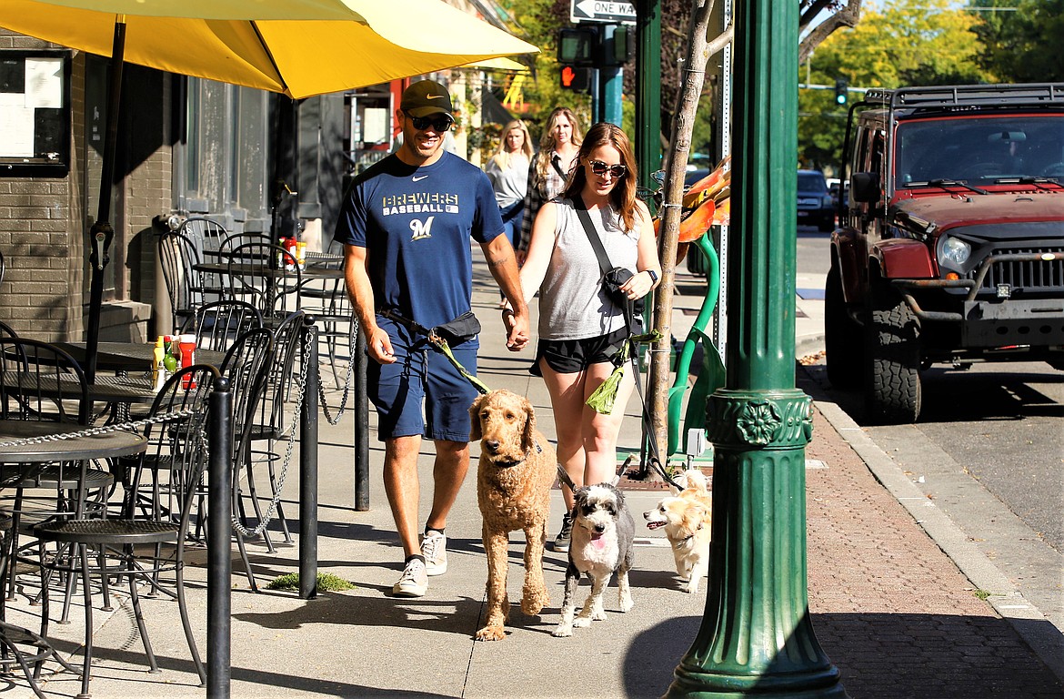 Eros Baca and Erin Carter of Portland walks their dogs Simba, Penny and Louie on Sherman Avenue on Wednesday.