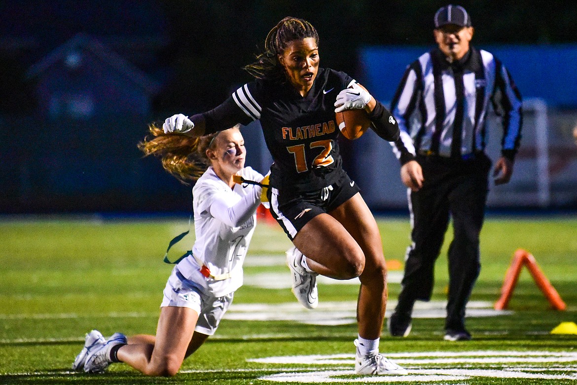 Glacier's Bella Hodous (14) makes a diving tackle as Flathead's Akilah Kubi (12) heads for the sideline on a run in the second half at Legends Stadium on Thursday, Sept. 22. (Casey Kreider/Daily Inter Lake)