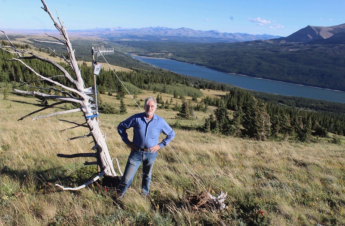 Doug Bonham, with technology startup Field Data Technologies, stands on the summit of Looking Glass Ridge just north of East Glacier as part of work to test a reimagined trail camera. The antenna next to him was receiving a signal from a test device located 12 miles away along the Heart Butte Cutoff Road. (Courtesy photo)