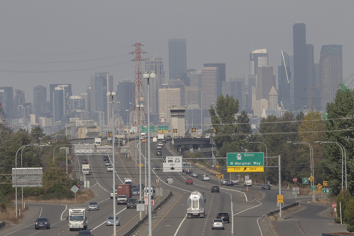 Cars cruise over the 1st Ave. bridge in front of a backdrop of a hazy Seattle skyline, Wednesday, Sept. 21, 2022. Smoke is making the air quality in downtown and North Seattle unhealthy for everyone, according to the Puget Sound Clean Air Agency. (Ellen M. Banner/The Seattle Times via AP)