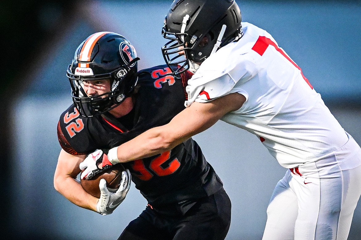 Flathead running back Gabe Lake (32) tries to break a tackle by Missoula Hellgate defensive lineman Calijah LaRance (7) in the first half at Legends Stadium on Friday, Sept. 23. (Casey Kreider/Daily Inter Lake)