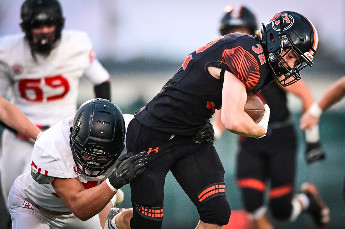 Flathead running back Gabe Lake (32) is brought down by Missoula Hellgate defensive end Nick Lowry (54) in the first half at Legends Stadium on Friday, Sept. 23. (Casey Kreider/Daily Inter Lake)