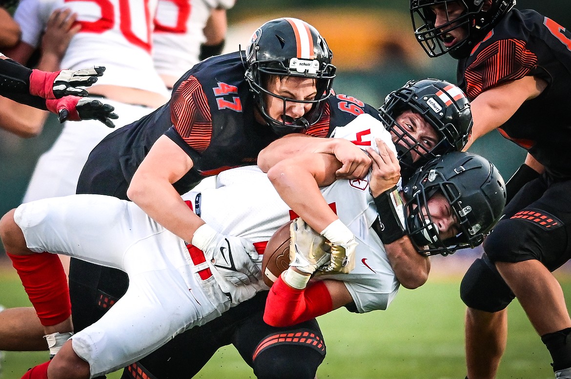 Flathead defenders Braden Capser (47) and Brandon Lewis (99) bring down Missoula Hellgate running back Alden Hellem (4) in the first half at Legends Stadium on Friday, Sept. 23. (Casey Kreider/Daily Inter Lake)