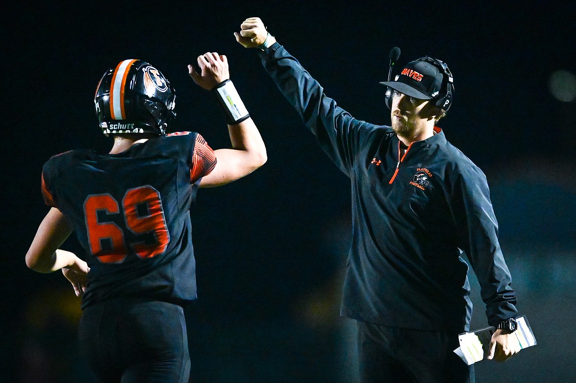 Flathead head coach Caleb Aland celebrates with defensive lineman Sawyer Troupe (69) after Troupe tackled Missoula Hellgate running back Alden Hellem in the end zone for a safety in the third quarter at Legends Stadium on Friday, Sept. 23. (Casey Kreider/Daily Inter Lake)