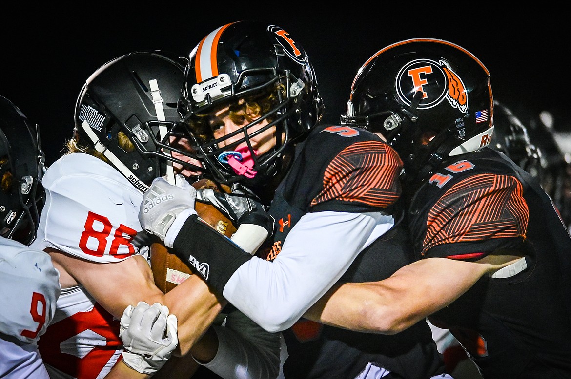 Flathead defenders Kaleb Sims (5) and Tanner Heichel (16) wrap up Missoula Hellgate kick returner Kort Lehman (88) in the second half at Legends Stadium on Friday, Sept. 23. (Casey Kreider/Daily Inter Lake)