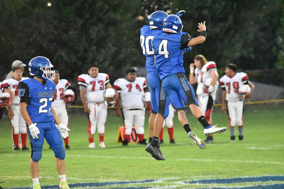 Warden junior Angel Lino Segoviano (80) and senior Ruben Becerra (4) jump and bump shoulders as the starting lineup for the Cougars is called Friday night.