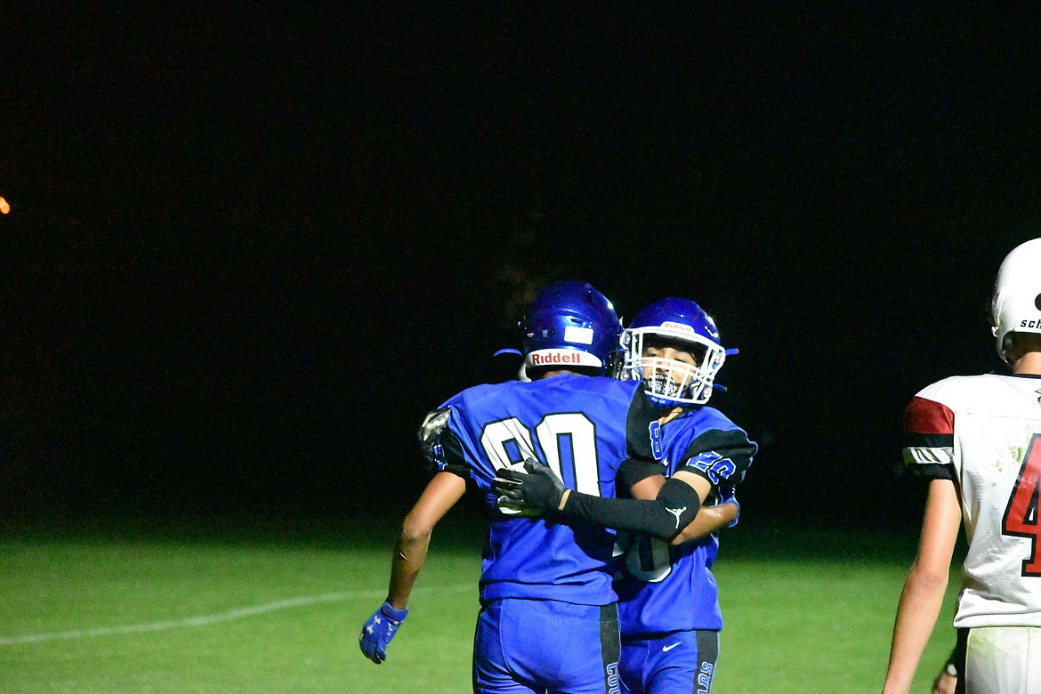 Junior Jair Perez-Chavez (20) hugs junior Angel Lino Segoviano (80) after Segoviano scores a touchdown for the Cougars.