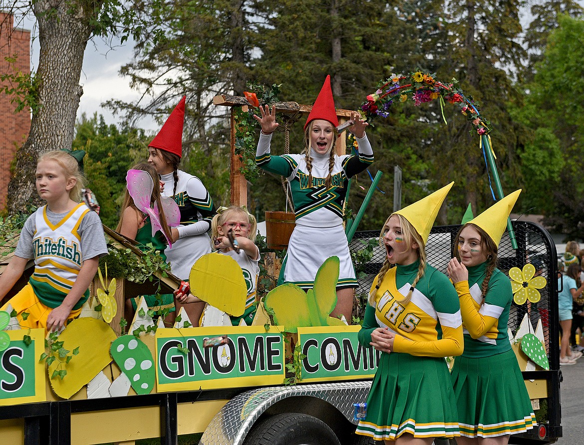 Cheerleaders throw candy to the crowd gathered along Second Street in the 2022 Whitefish Homecoming Parade. (Whitney England/Whitefish Pilot)