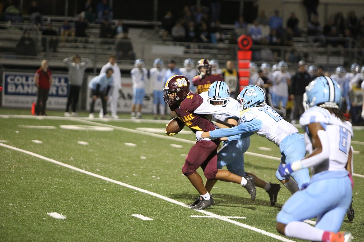 Moses Lake receiver Kyson Thomas pushes off Central Valley defenders to fight for extra yardage in the Maverick’s 25-22 win on Friday.