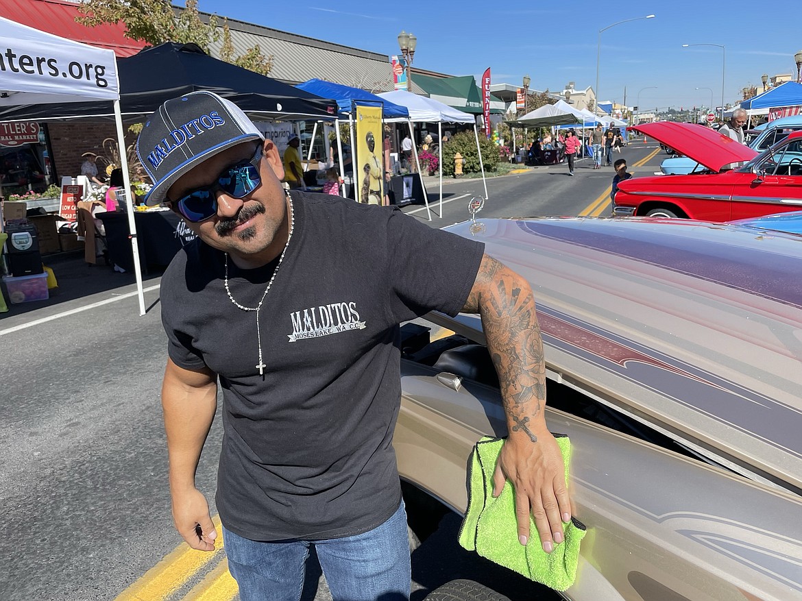 Giovanni DeLeon wipes his customized 1996 Cadillac Fleetwood Brougham lowrider, one of a number of lowriders on display along Third Avenue in downtown Moses Lake during the Umani Festival, a celebration of Hispanic heritage organized by the Moses Lake Public Library and the Downtown Moses Lake Association last Saturday.