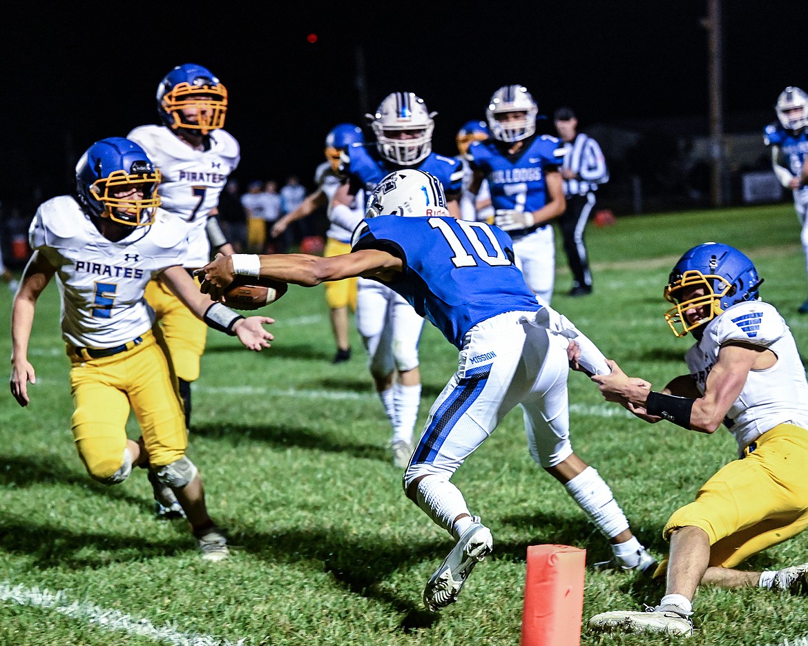 Mission Bulldog quarterback Kellen McClure drags a Victor Pirate defender towards the endzone. (Christa Umphrey Photo)