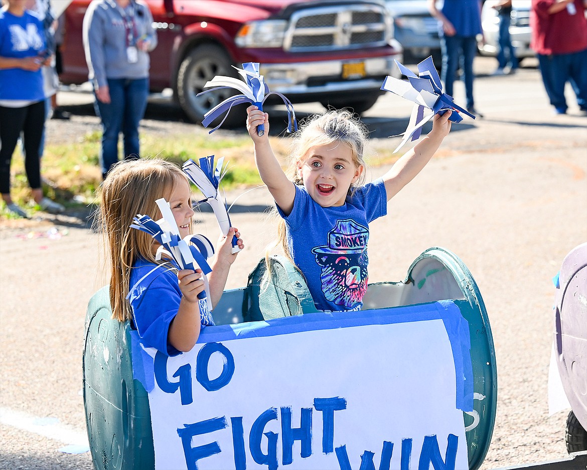 A couple of youngsters cheer on the Mission Bulldogs during Friday afternoon’s homecoming parade. (Christa Umphrey Photo)