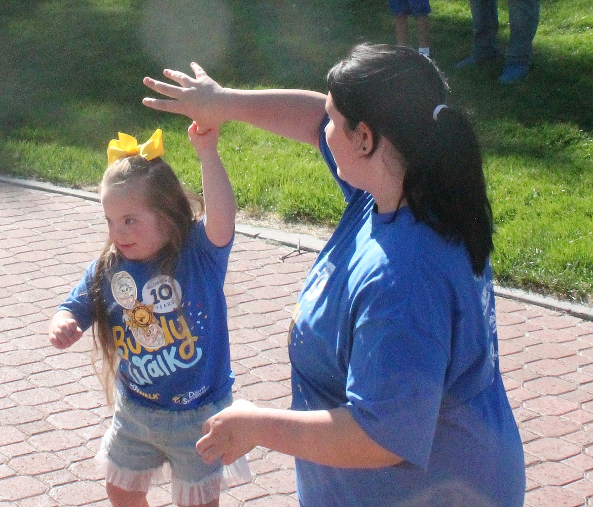 Five-year-old Cheyenne Aubart dances with family friend Lily Ochoa during the warmup to the Buddy Walk Saturday.
