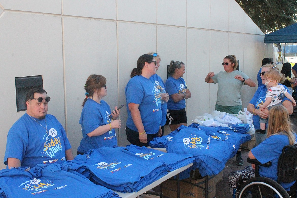 Volunteers visit and hand out T-shirts at the Down Syndrome Society of Grant County’s 10th annual Buddy Walk Saturday afternoon. The event allows those with Down syndrome to show appreciation for those who help them through life’s challenges.