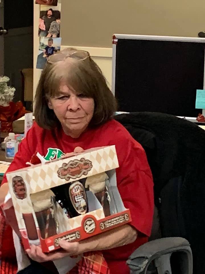 Patti Trujillo mulls over a gift at an office Christmas party. She was known for a sarcastic sense of humor and for always helping those around her.