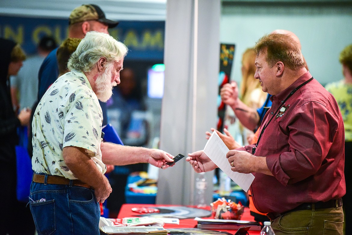 Eddie Wise, right, Operations Manager with Integrated Security Solutions in Kalispell, shakes hands with an attendee after giving him a business card at the 2022 Job & Veteran Opportunity Fair at the Flathead County Fairgrounds Expo Building on Wednesday, Sept. 28. (Casey Kreider/Daily Inter Lake)