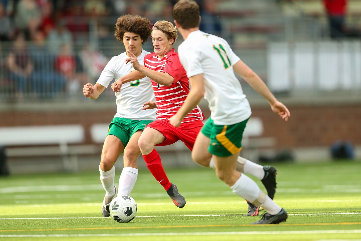 Sandpoint senior Shawn Russell maneuvers his way through two Lakeland defenders to score a goal. The Bulldogs won the game, 8-0.