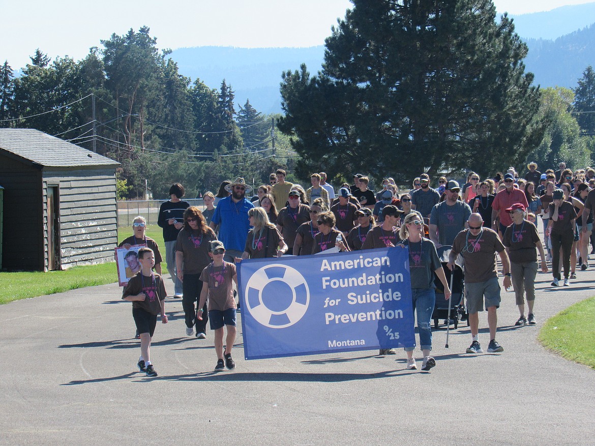 Nearly 350 community members participated in the Flathead Valley’s Out of the Darkness Walk Sept. 25 to raise awareness about suicide prevention. 
The walk is part of a national event held annually on the last Sunday of September, which is National Suicide Prevention Month. 
Teams and groups join to also raises awareness about mental health issues, as well as honors those lost to suicide.
This year’s guest speaker was Teigan Avery. Teams and groups join to fight suicide and honor those they have loved and lost to suicidePictured is the top fundraising Team Red Rock leading the way carrying the AFSP banner. 
A quilt was made for the event and donated for the silent suction held during the event.
To date, approximately $20,000 has been raised by the Flathead Valley Walk for the American Foundation for Suicide Prevention.