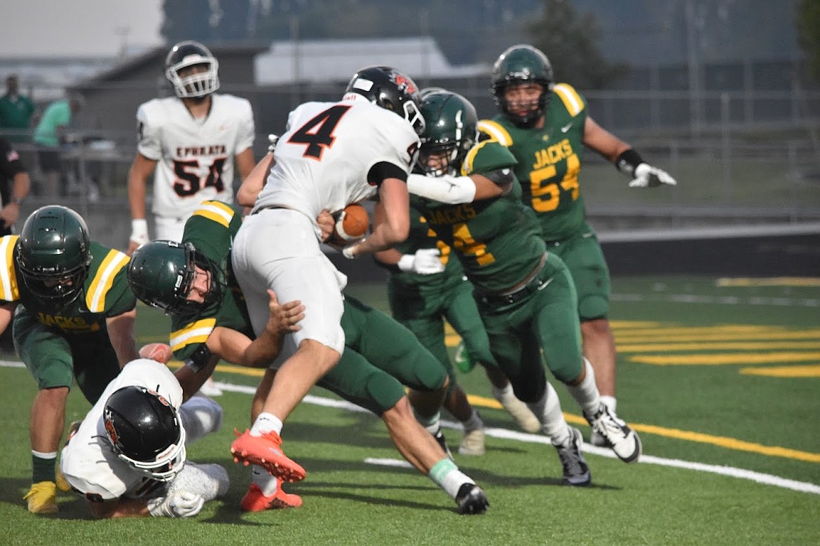 A group of Quincy defenders work to force a tackle during Quincy’s game against Ephrata on Sept. 9.