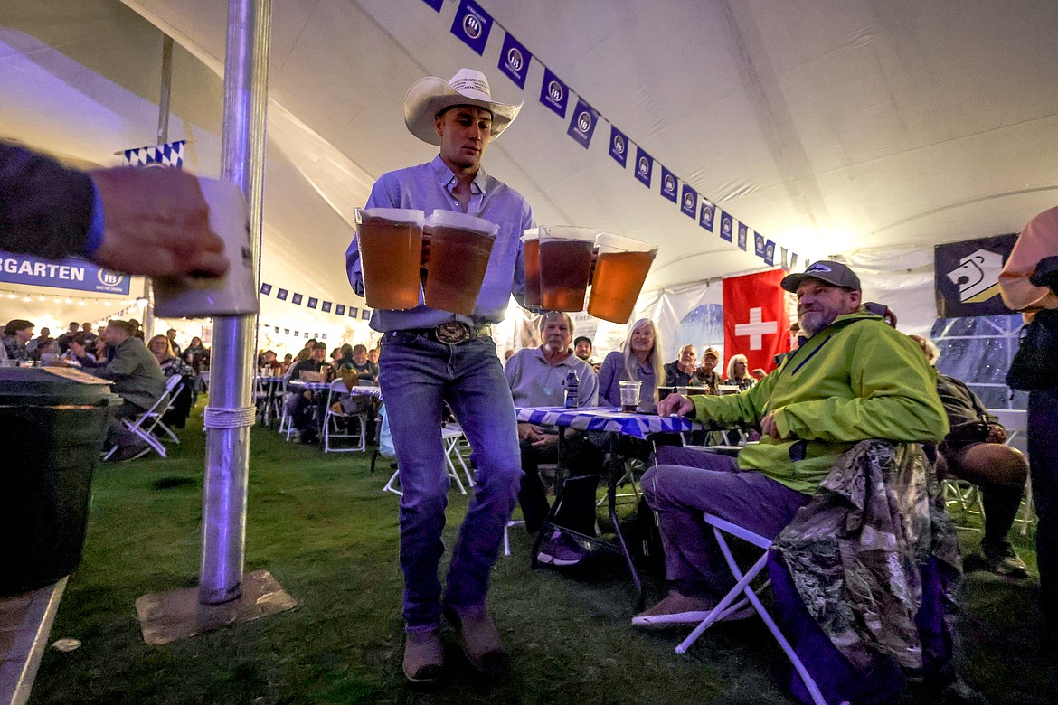 Competitors carry pitchers of beer during a competition at Oktoberfest on Local's Night. (JP Edge/Hungry Horse News)