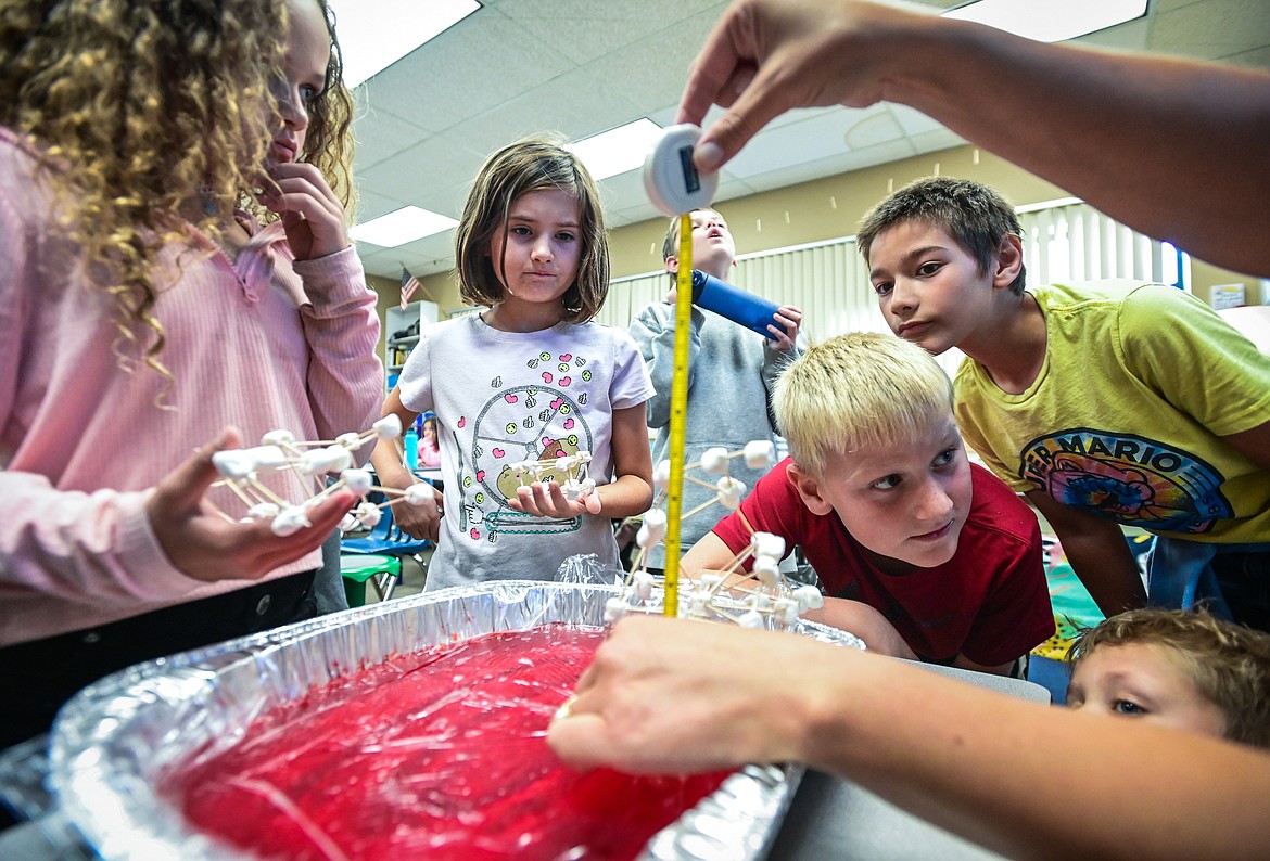 Fourth-grade teacher Karissa Prewitt measures the height of a structure built with toothpicks and marshmallows as students test their creations' resistance to earthquakes on a dish filled with Jell-O at Peterson Elementary School on Friday, Sept. 30. (Casey Kreider/Daily Inter Lake)