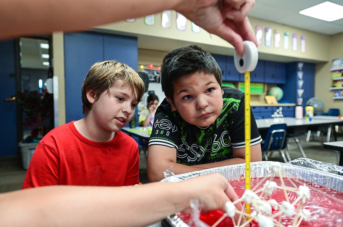 Fourth-grade teacher Karissa Prewitt measures the height of a structure built with toothpicks and marshmallows as students test their creations' resistance to earthquakes on a dish filled with Jell-O at Peterson Elementary School on Friday, Sept. 30. (Casey Kreider/Daily Inter Lake)