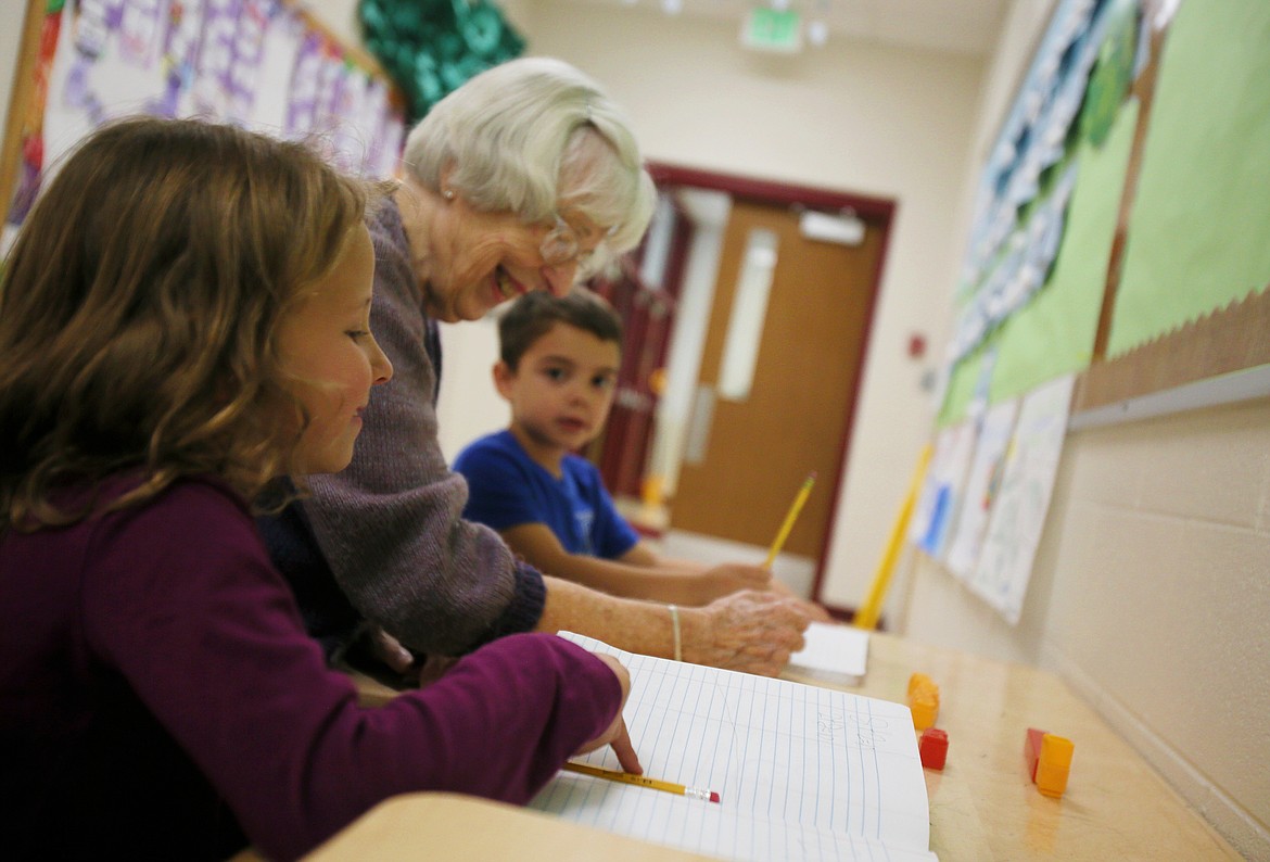 First-graders Emma Worden and Thomas Ely work on math problems with "Miss Janet" Crane at Ramsey Magnet School of Science on Thursday. Crane is a dedicated volunteer who has helped out at the school for 17 years.