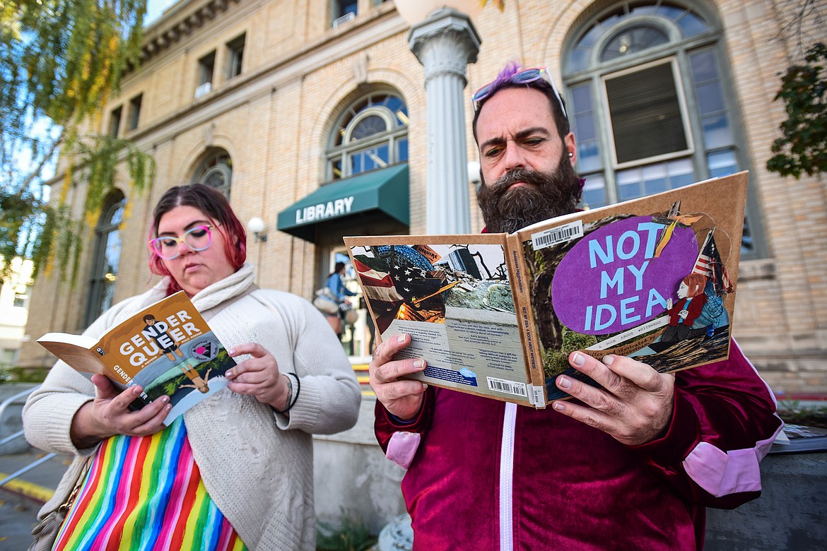 Felicia Caflin, a board member with Glacier Queer Alliance, and Bryan Bebb, the Alliance's executive director, read two recently-challenged books during a read-in to highlight social justice and censorship issues outside ImagineIF Library in Kalispell on Saturday, Oct. 1. (Casey Kreider/Daily Inter Lake)