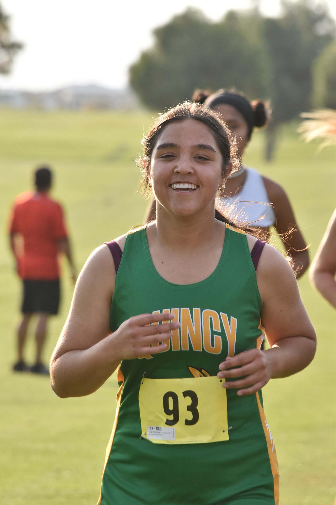 Quincy junior Crystal Espinoza smiles as she runs the race.