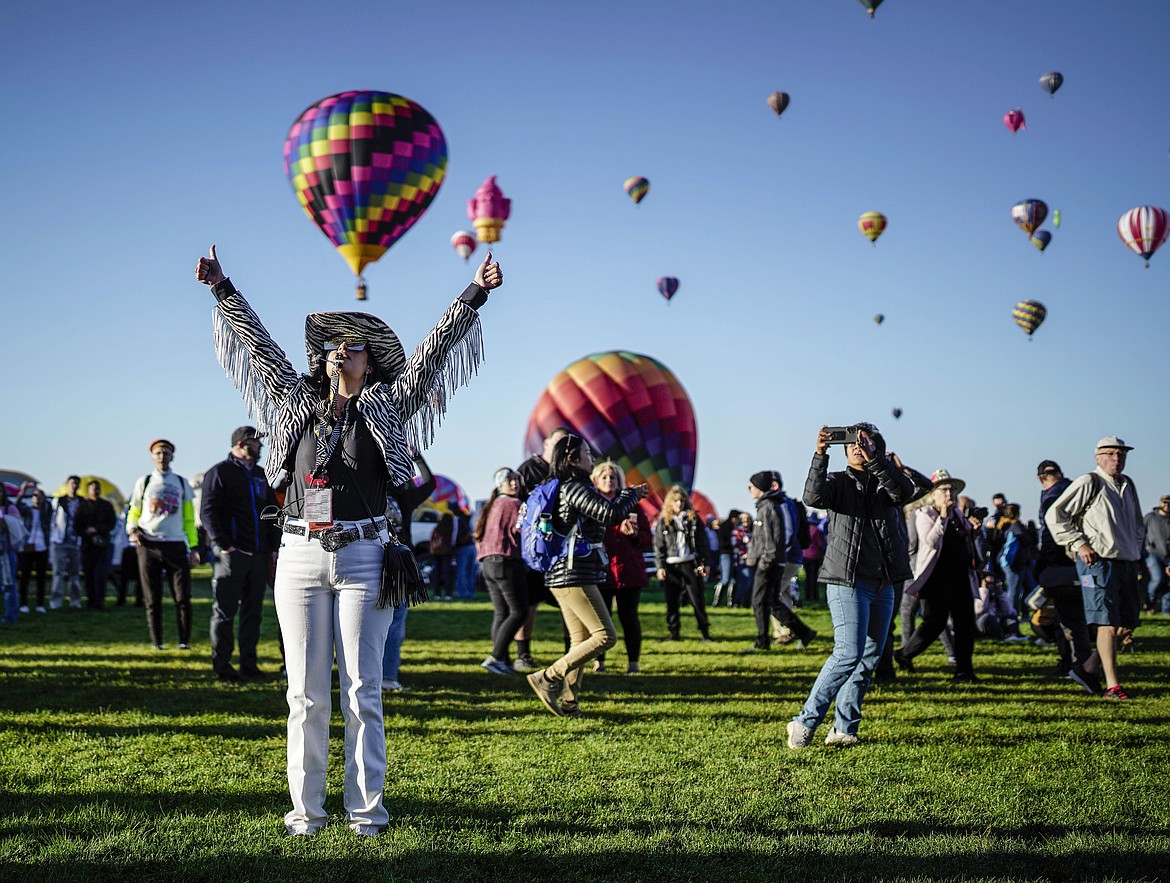 Nicole Tagart, a launch official with the 50th annual Albuquerque International Balloon Fiesta, signals a balloonist to take off in Albuquerque, N.M., on Saturday, Oct. 1, 2022. (Roberto E. Rosales/The Albuquerque Journal via AP)