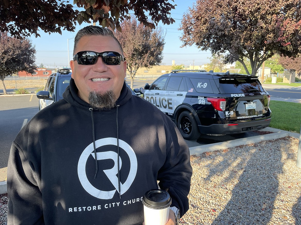 Restore City Church Pastor and Moses Lake Police Department Chaplain Mike Alvarado with a big cup of coffee during the Cops, Cars and Coffee fundraiser on Saturday morning. Alvarado’s church provided free donuts for the fundraiser after the MLPD announced it was a ”bring your own donut” event.