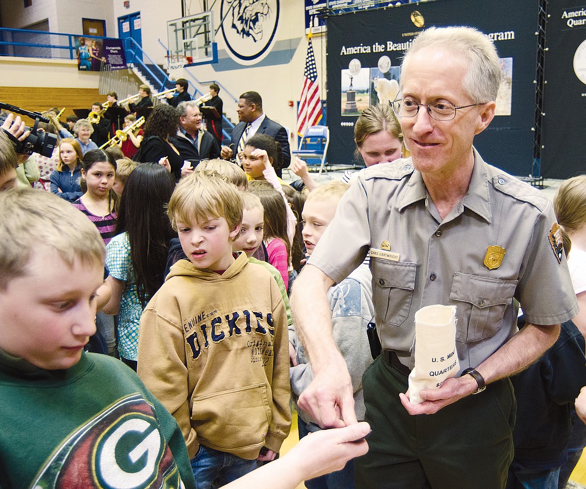 Glacier National Park Superintendent Chas Cartwright hands out coins to Canyon Elementary students during a ceremony commemorating the new Glacier National Park quarter in this 2011 file photo. (Daily Inter Lake FILE)