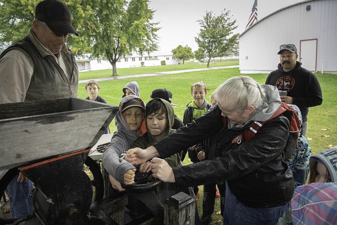 Bruce Beckstead teaches students how to make apple cider at Ag Days at the Sanders County Fairgrounds. (Tracy Scott/Valley Press)