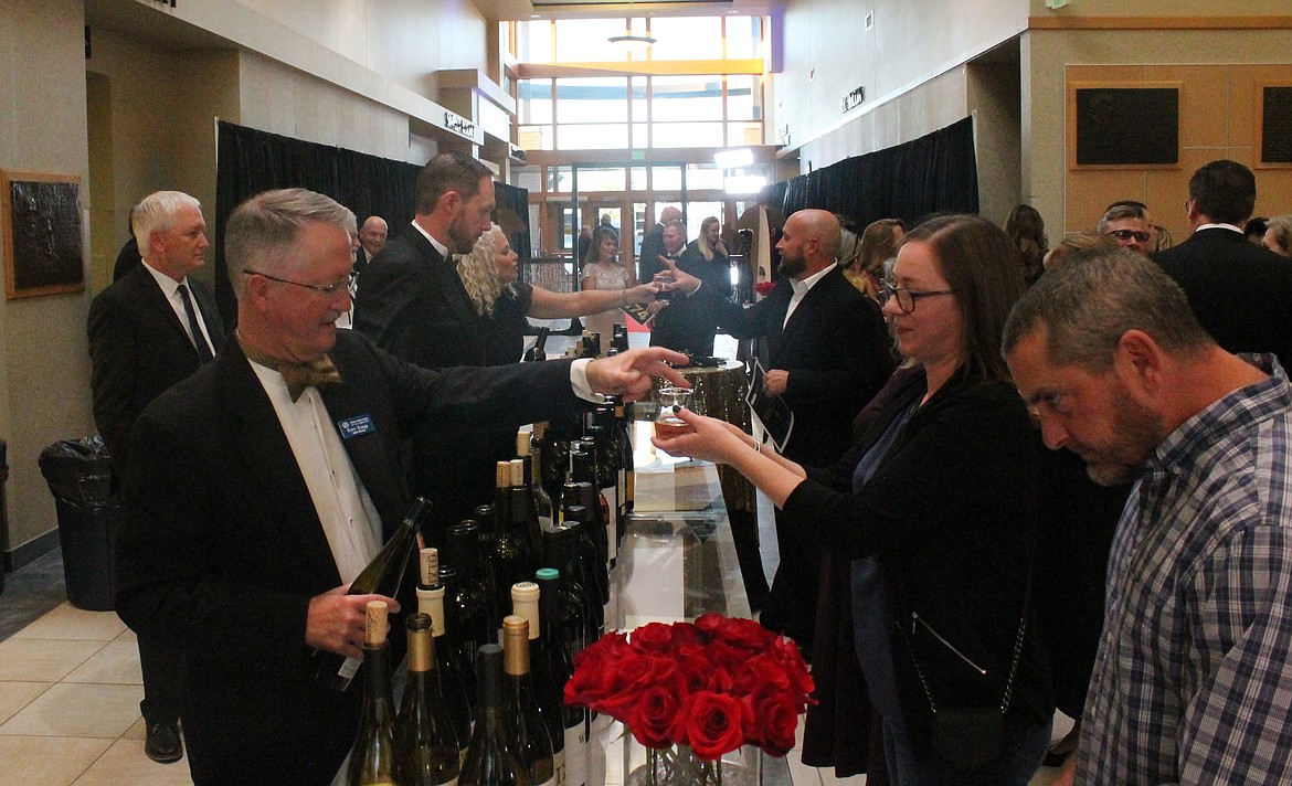 Boys & Girls Clubs of the Columbia Basin board member Rory Knapp, left, pours a glass of wine for Naomi Bridgeford of Moses Lake at the club’s dinner and auction Saturday night. More than 50 wines were available for tasting, according to club Director Kim Pope.