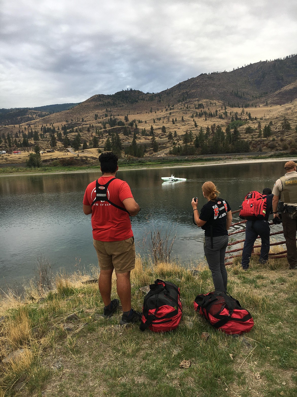 Rescue crews stand along the shore of the Flathead River near Perma after a plane crashed into the river on Sunday. (Jack Bodnar photo)