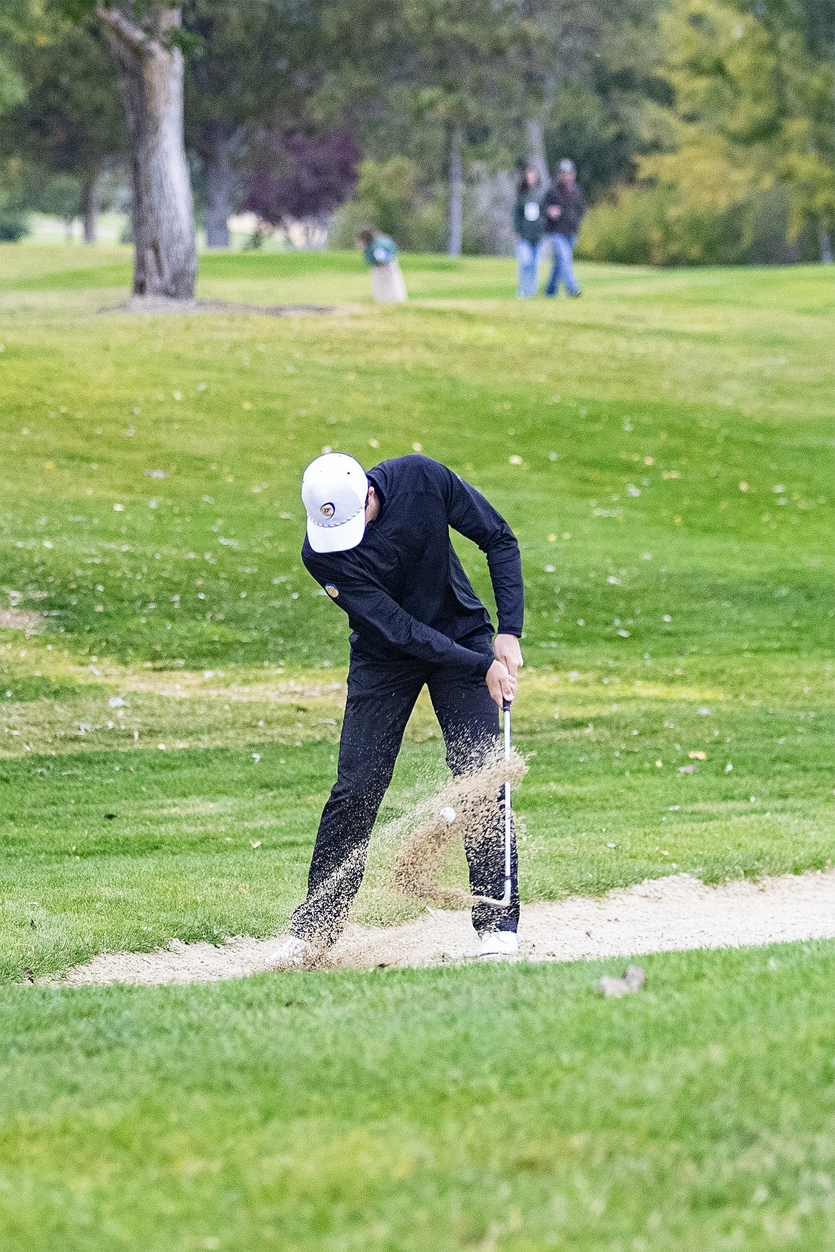 Polson Pirate Epsn Fisher chips one out of the sand trap and onto the green on hole #16 during the Class A State Championship hosted at the Hamilton Gulf Club on Saturday. (Rob Zolman / Lake County Leader)